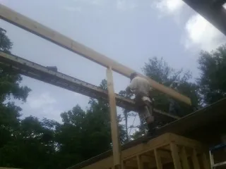 Carpenter setting a ridge beam over a new addition frame — Ice Dam Removal by Roofing Brothers in Coulee City